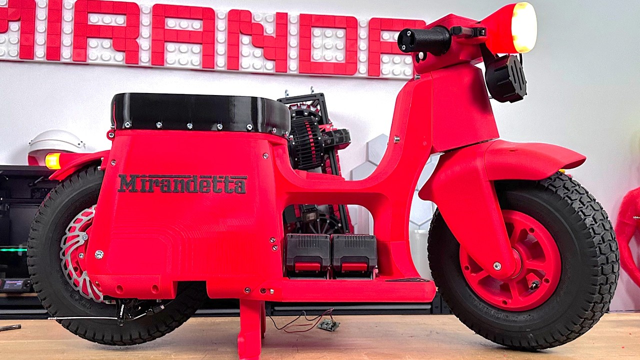 Side view of red Mirandetta motorbike indoors with headlight on
