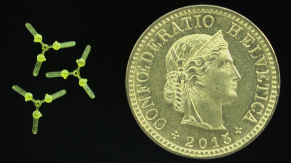 Three small yellow rotors beside a Swiss coin dated 2013.